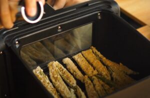 Air fryer basket filled with coated okra