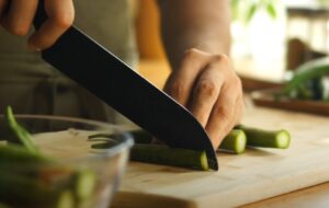A chef's hands expertly slice okra