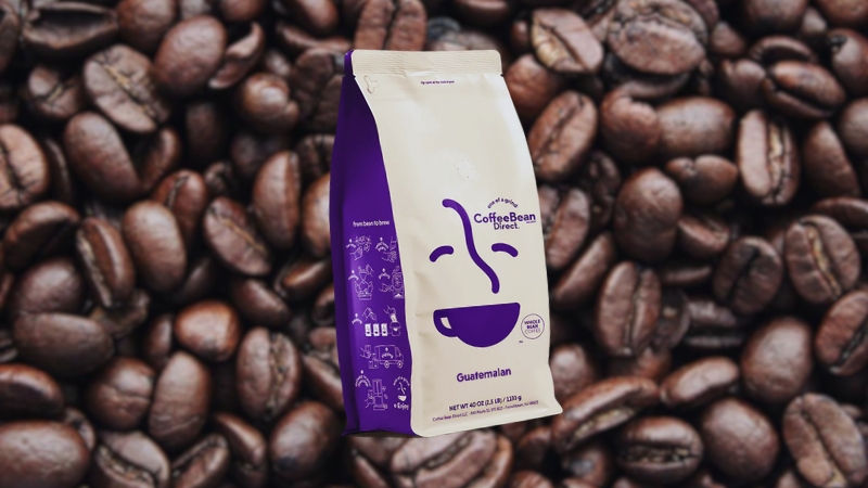 Direct Dark Guatemalan Coffee Bag Placed in Front of A Background of Roasted Coffee Beans