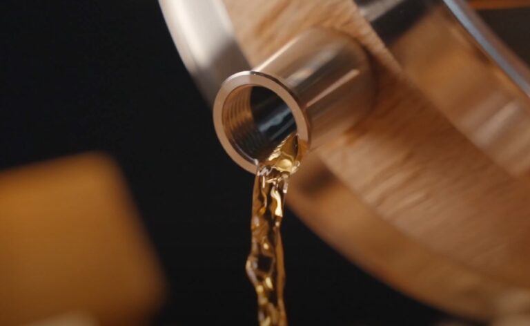 Amber liquid cascades from a metal spout