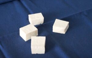 Tofu slices on a blue paper