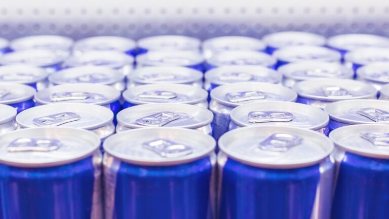 Rows of unopened blue cans of energy drinks stacked on a shelf