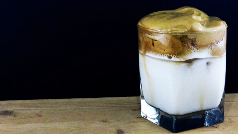 Iced Dalgona coffee in a glass with whipped coffee foam on top